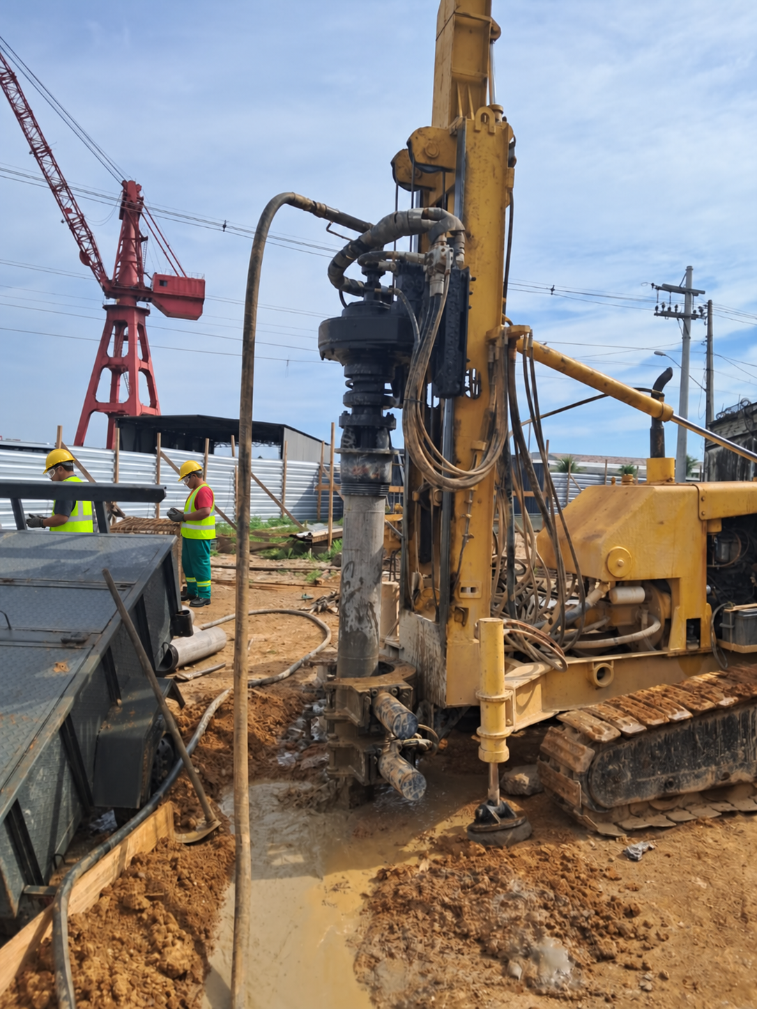 Equipe com EPIs e equipamento executando estacas em obra acompanhada pela GCB Engenharia